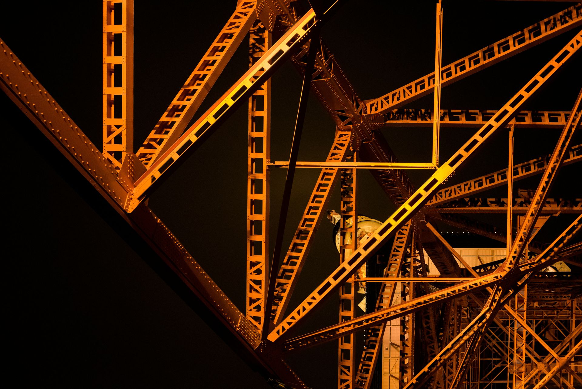 Orange illuminated steel girders of Tokyo Tower against a dark night sky